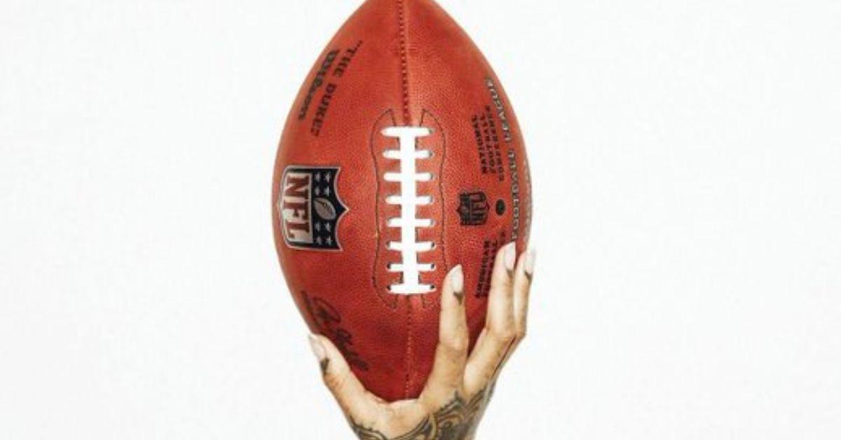 Rihanna hält einen NFL-Football in der Hand, um ihren Super-Bowl-Auftritt anzukündigen. 