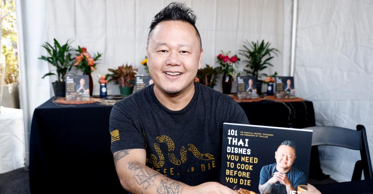Chef Jet Tila posando com seu livro "Pratos tailandeses que você precisa cozinhar antes de morrer"