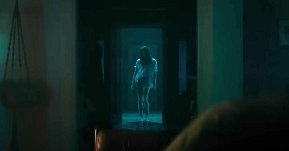 Ellie (Alyssa Sutherland) em 'Evil Dead Rise' age assustadoramente em uma porta 