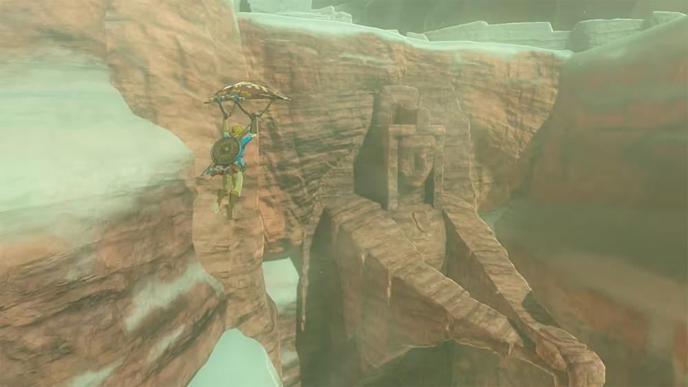 Link usa il suo aliante per viaggiare nel cielo con un bioma roccioso sullo sfondo.