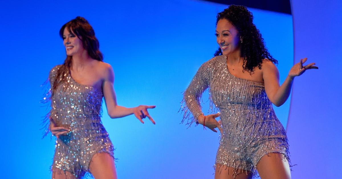 Chelsea Hobbs et Tamera Mowry sourient et dansent devant un fond bleu dans 'Dance Moms'.