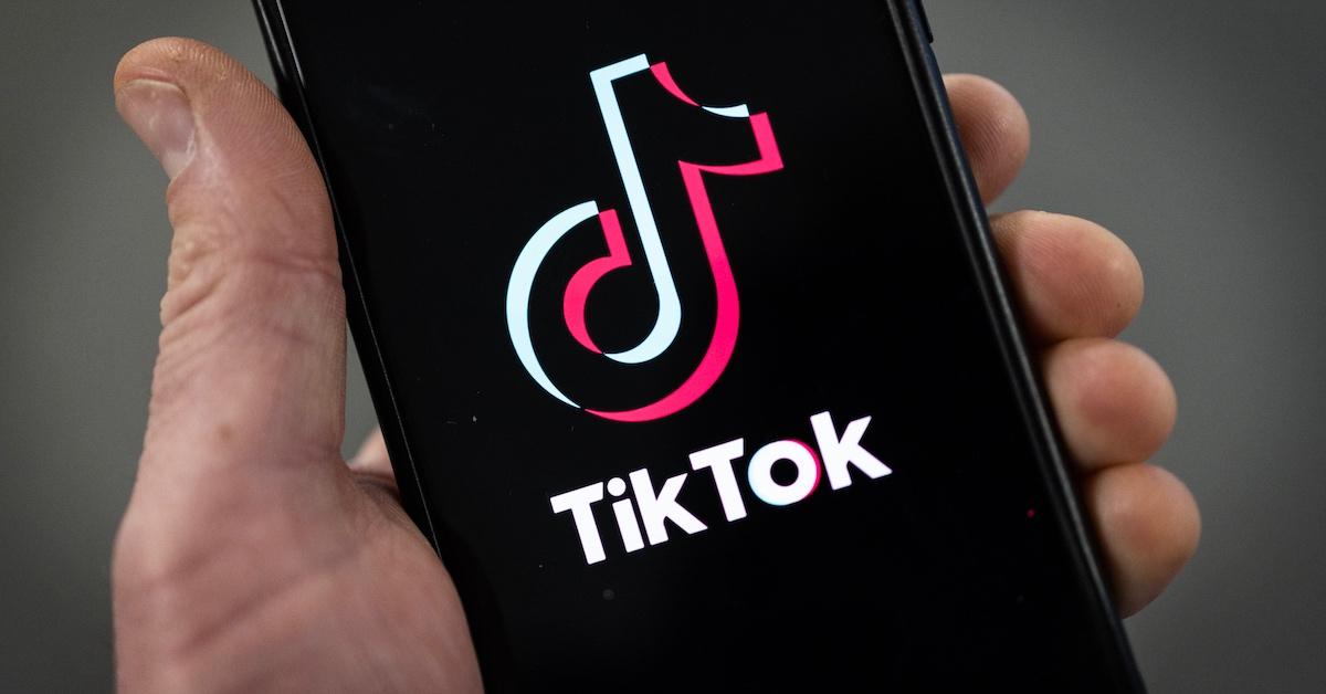 手持带有 TikTok 标志的智能手机的人