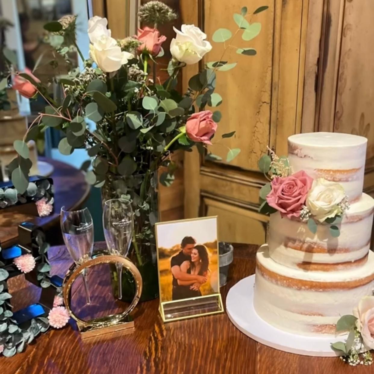 꽃과 샴페인 잔이 있는 웨딩 케이크 테이블