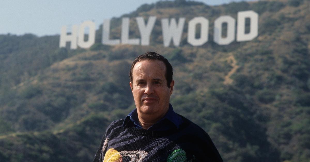 肯尼斯·安格 (Kenneth Anger) 在洛杉矶的好莱坞标志前摆姿势。
