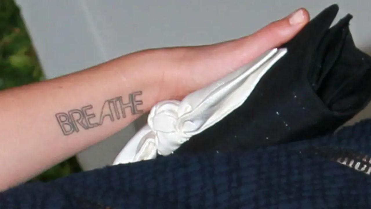드류 베리모어의 왼쪽 손목에 새겨진 'Breathe' 문신