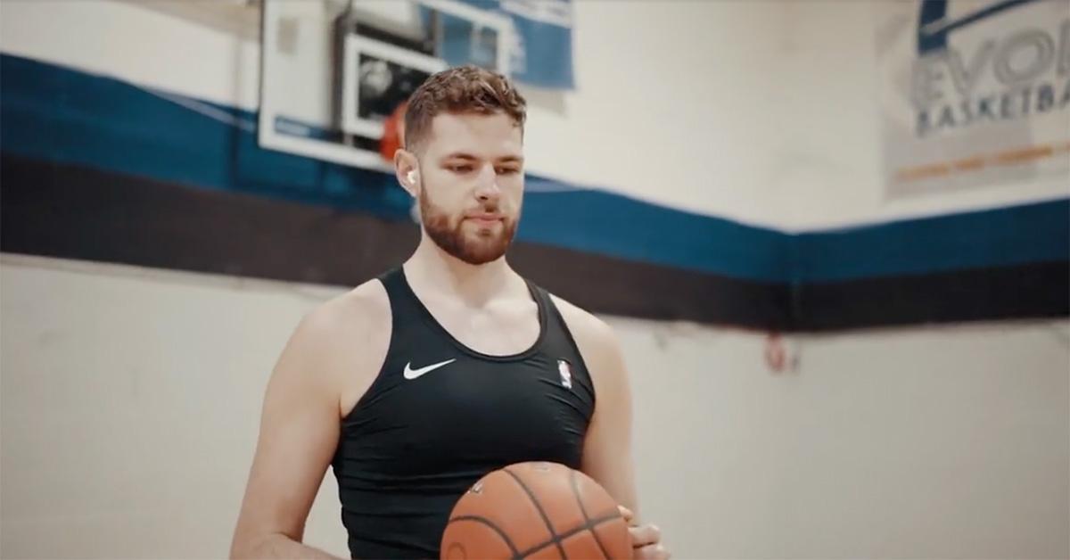 Hunter Dickinson em uma academia segurando uma bola de basquete.