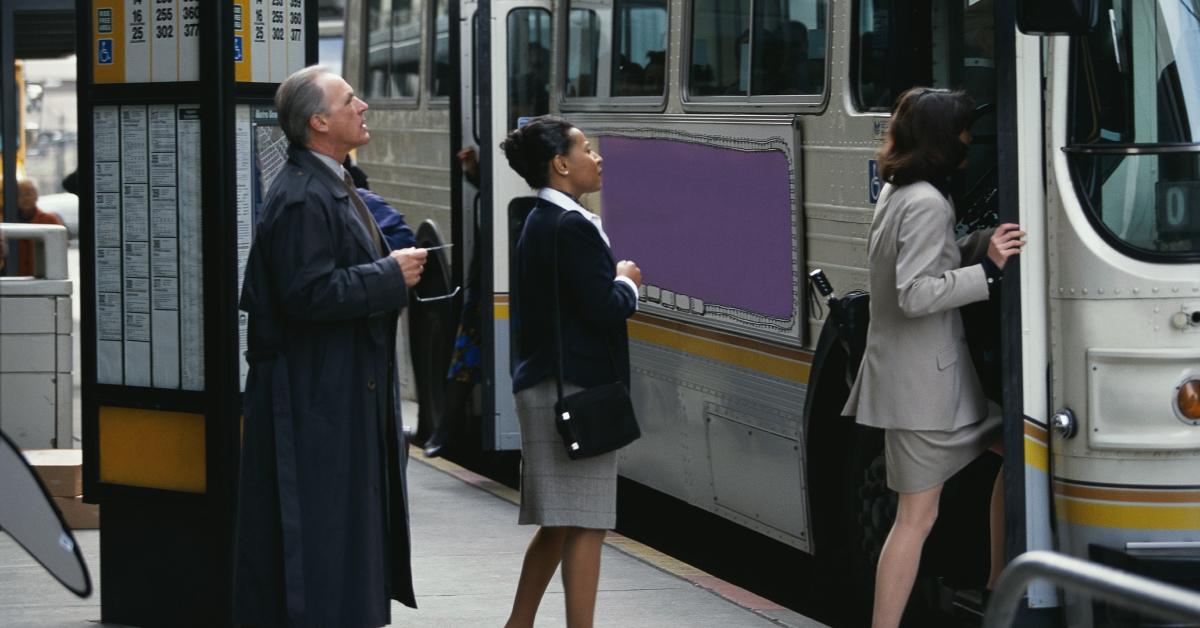 Affärsmän som går ombord på en buss.