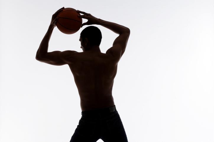 Silhouette d'un homme tenant un ballon de basket 