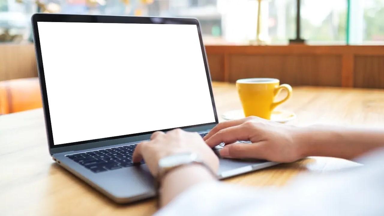 빈 흰색 데스크탑 화면이 있는 노트북 터치패드를 사용하고 작업하는 여성