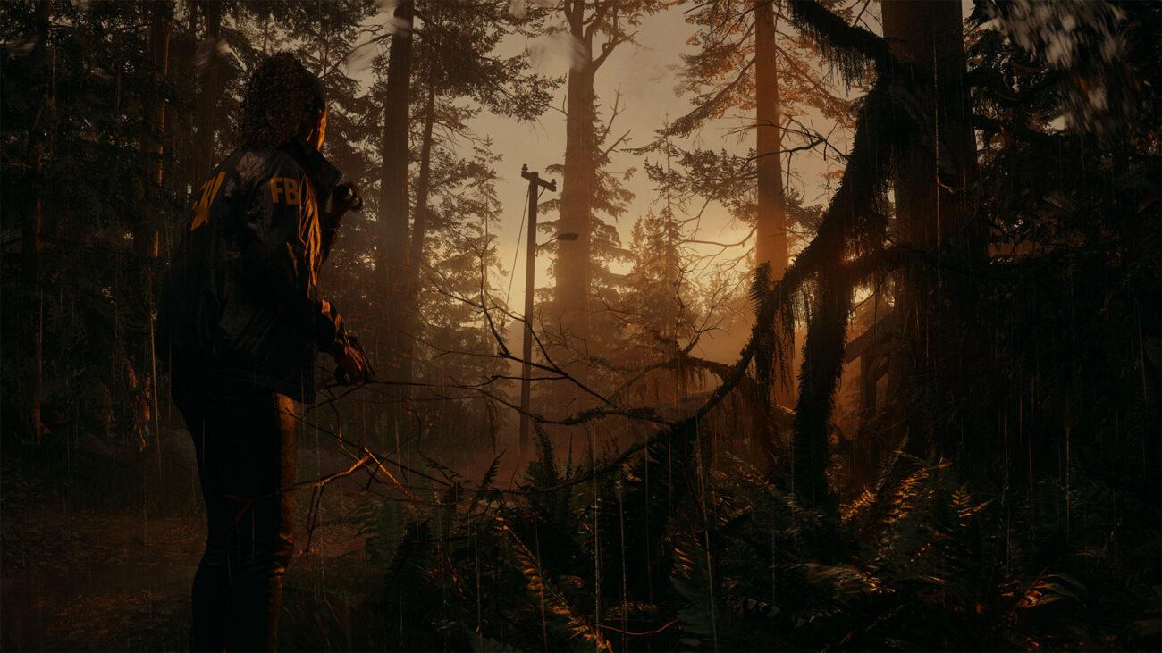 'Alan Wake 2' Saga Anderson in piedi in una foresta piovosa al tramonto.