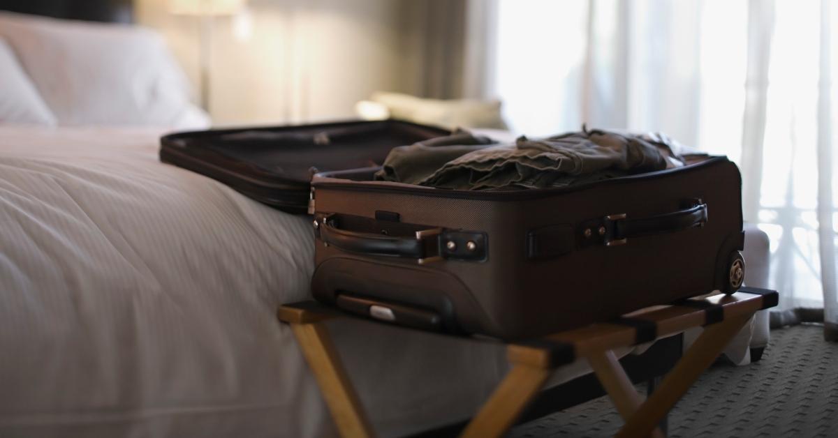 valigia aperta dal letto nella camera d'albergo