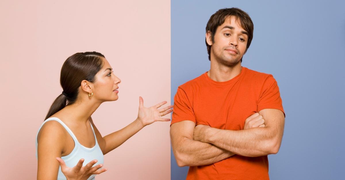 Un uomo e una donna discutono davanti a uno sfondo rosa e blu