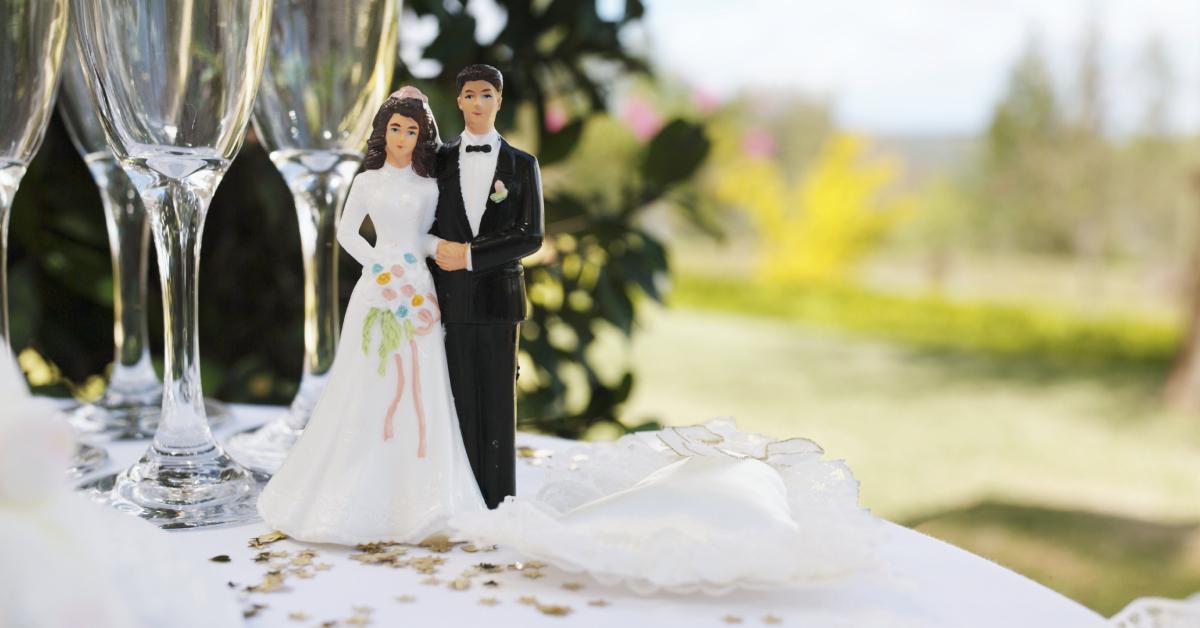 Figurina dello sposo e della sposa sulla tavola dai flauti di champagne.