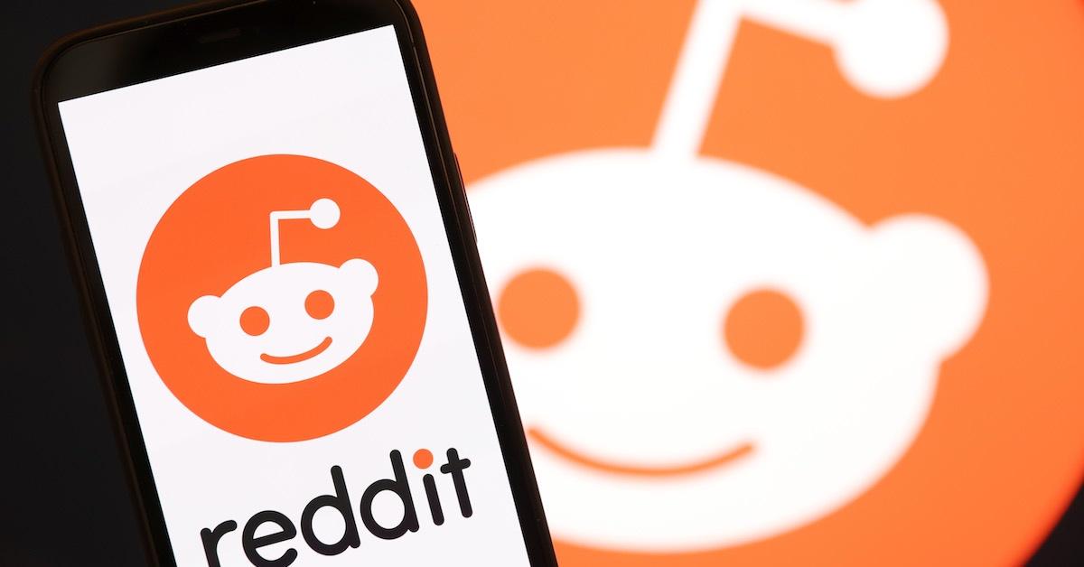 Un logo Reddit visualizzato sullo sfondo e su uno smartphone