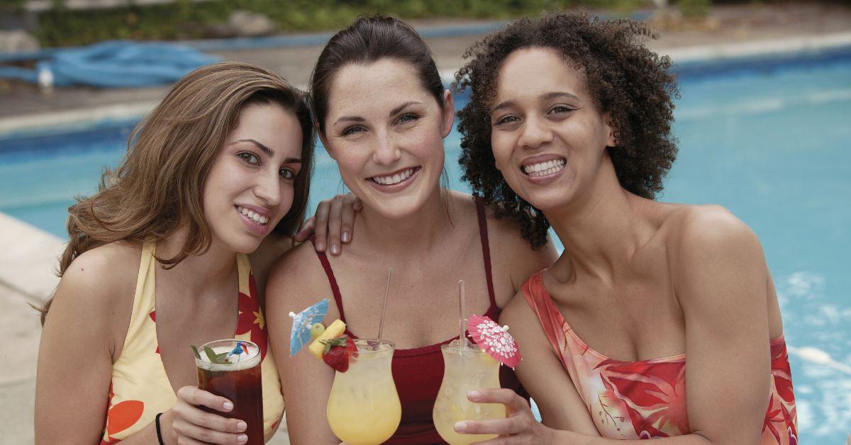 一群朋友在泳池边喝热带饮料。