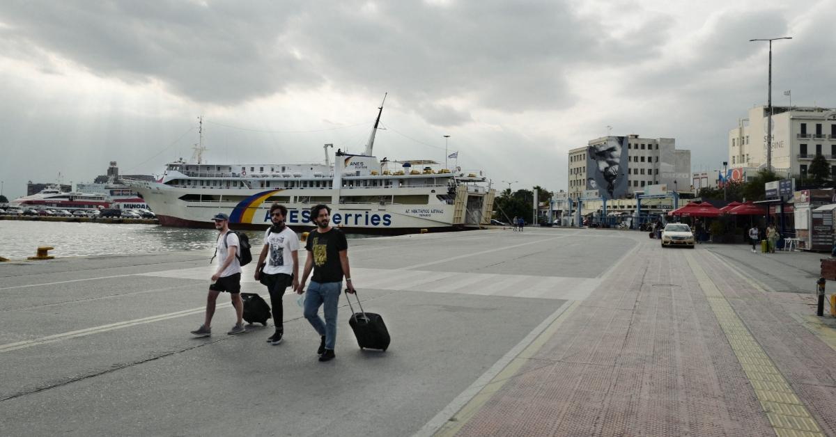 Os turistas se preparam para embarcar em uma balsa para as ilhas gregas da cidade portuária grega de Pireu