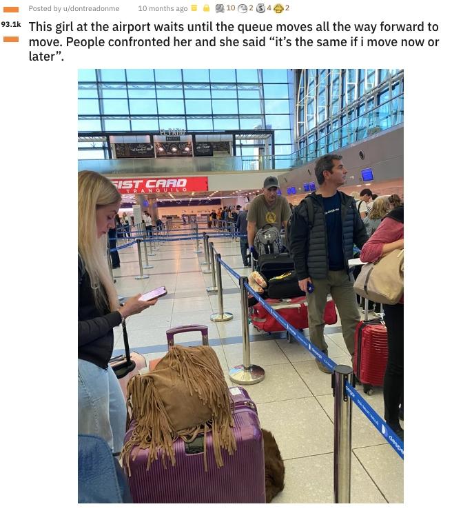 Una donna all'aeroporto al telefono si rifiuta di spostare le valigie più in alto nella fila.