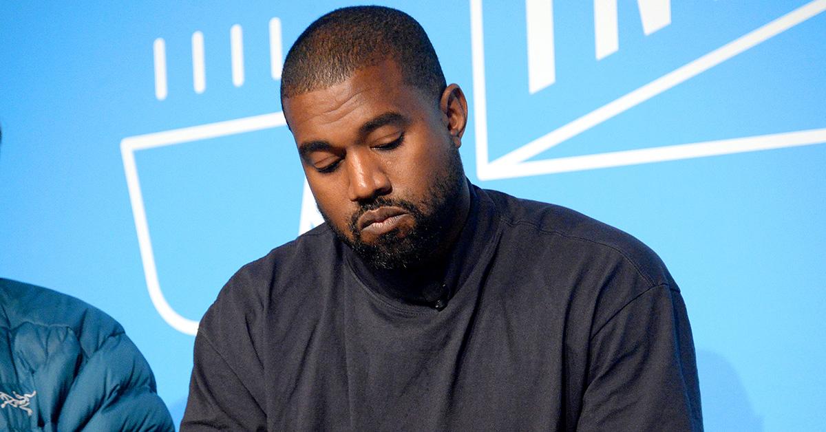 Kanye West blickt im Jahr 2020 auf einen Yeezy-Schuh herab. 