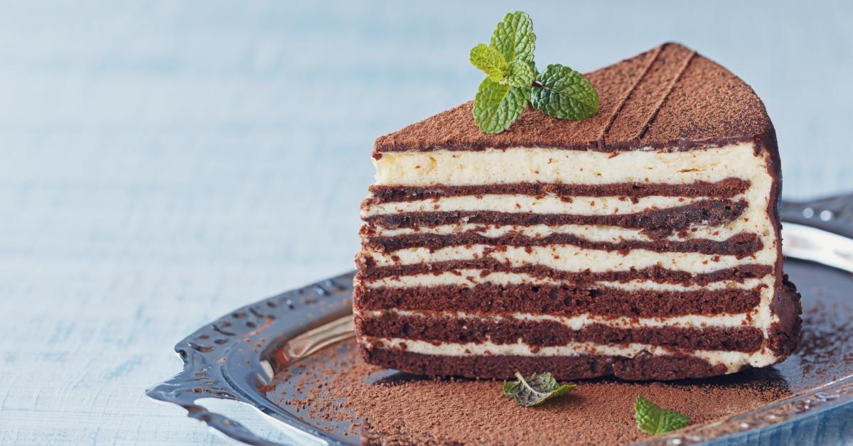 En skive chokoladekage (med vaniljeglasur mellem lagene) på et sølvfad.