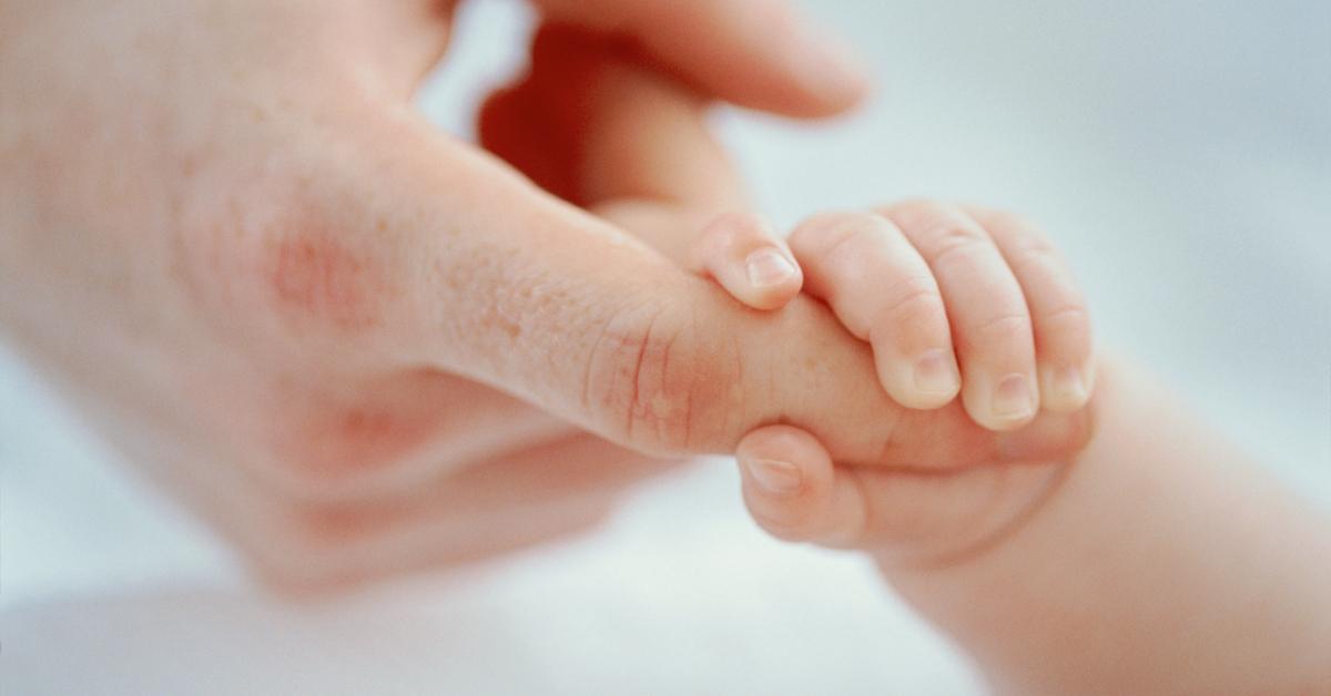 男の指を握る赤ちゃんの手。