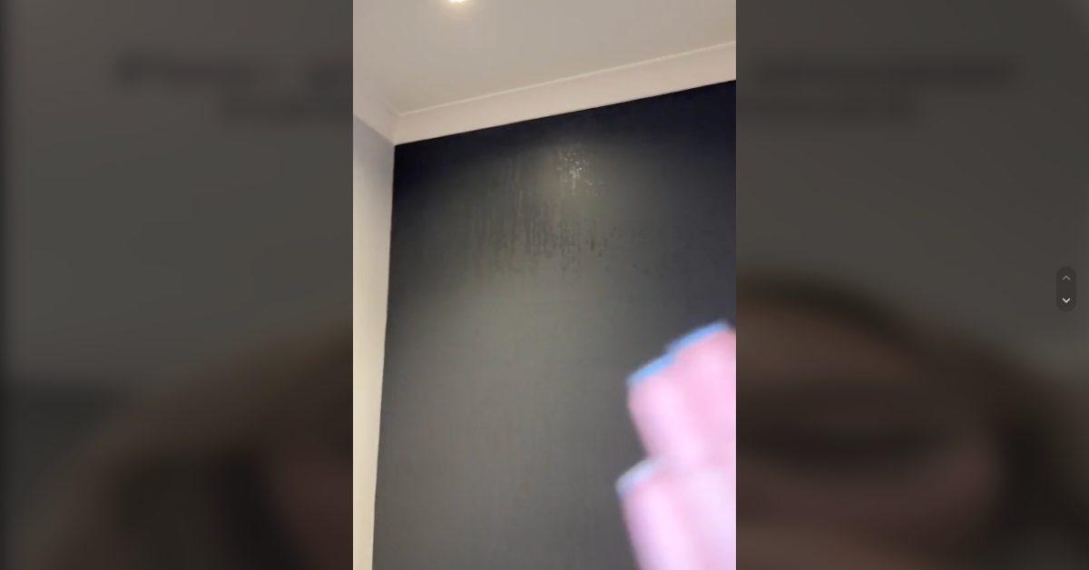 Uma mulher mostra a condensação nas paredes do banheiro