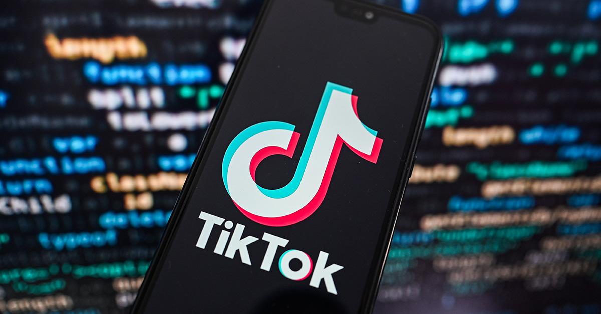 Le logo TikTok sur un fond de code flou. 