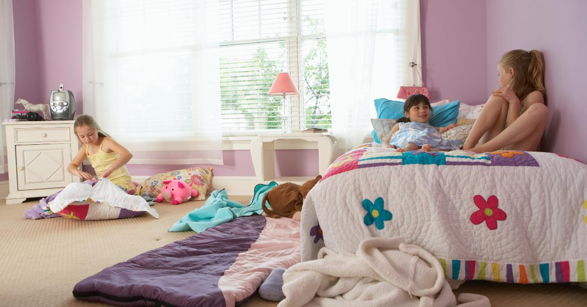 Tre unga flickor som sitter och pratar i ett sovrum.