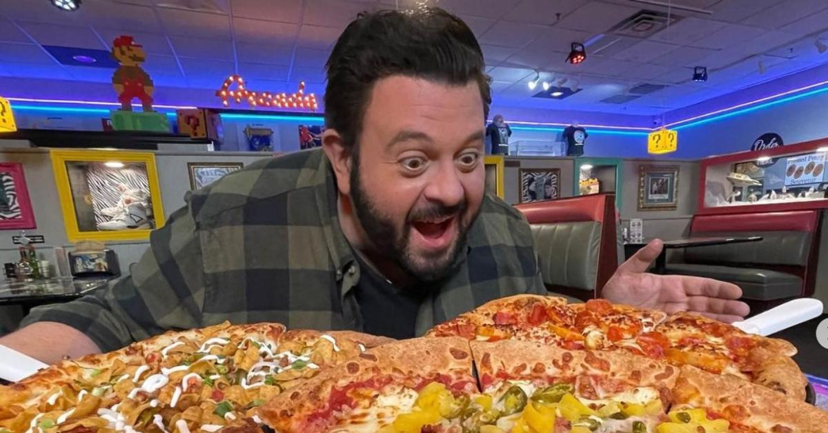 TV-personlighet Adam Richman beundrar tre pizzapajer. 