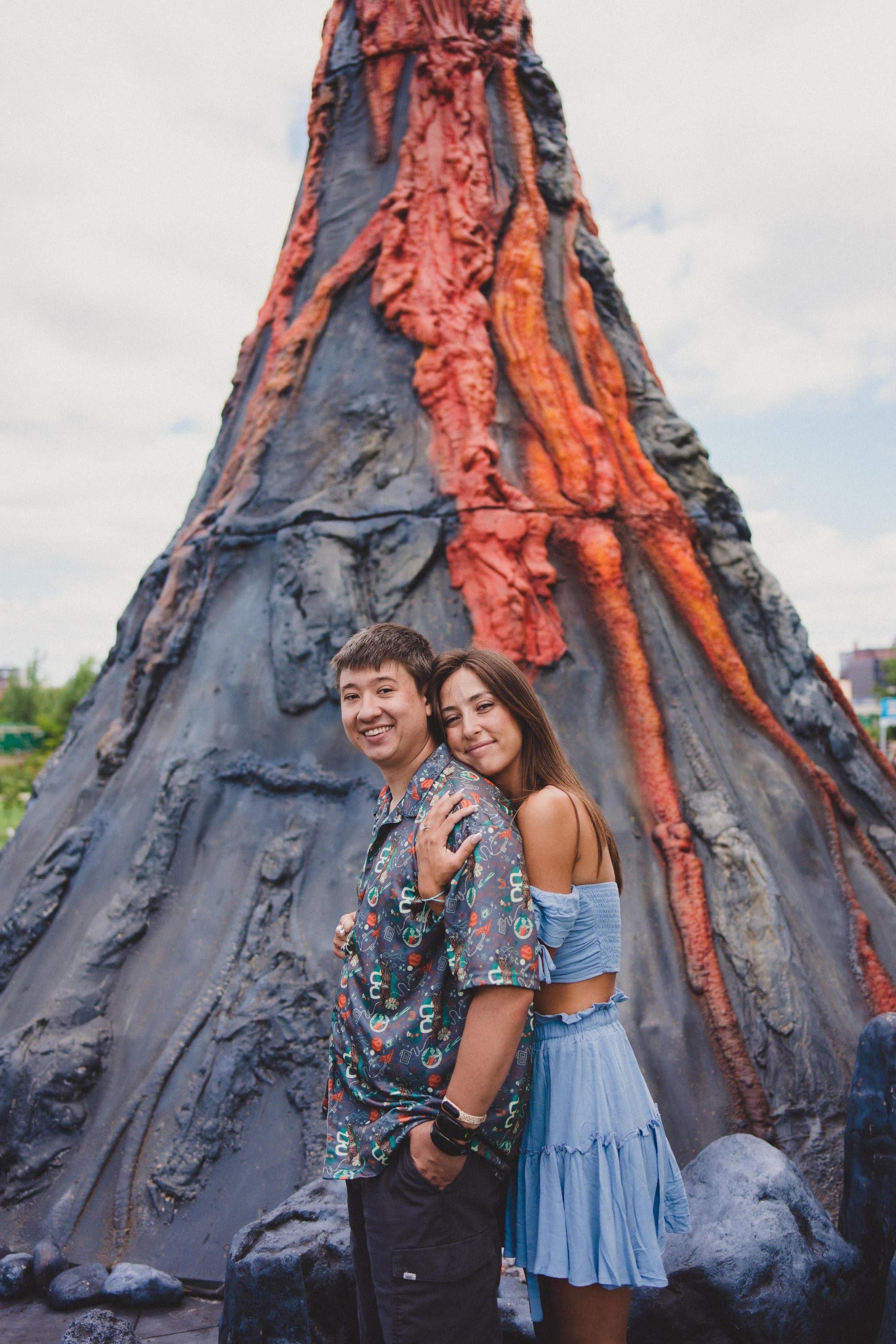 Brad et Kelsi posant devant la séance photo du volcan au NYC GO Fest.