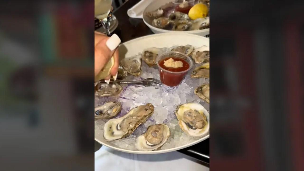オイスターバーでのデートで牡蠣を食べる女性