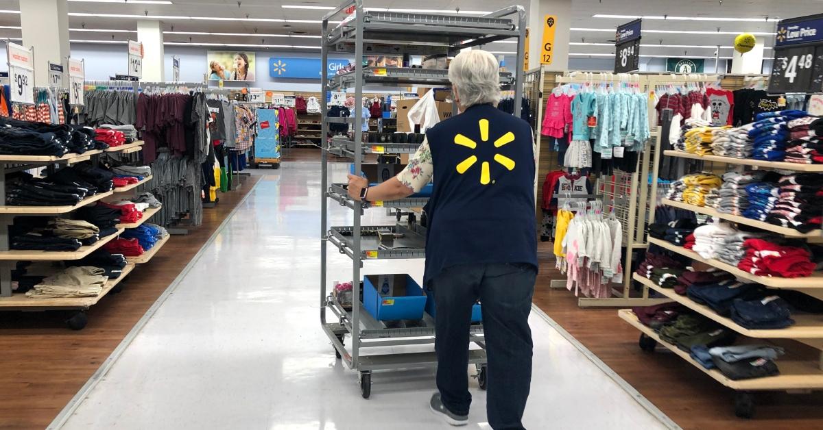 Un dipendente Walmart spinge un carrello attraverso un negozio Walmart
