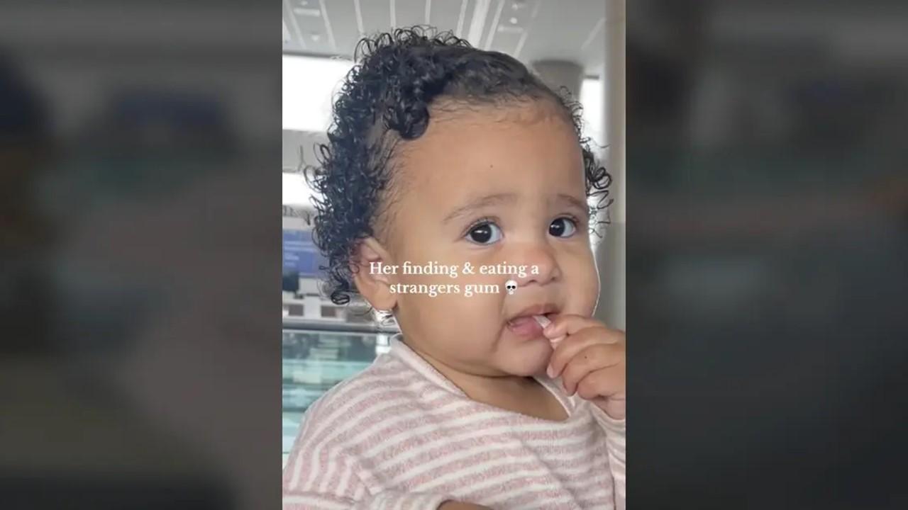 Bebisen stoppar tandköttet i munnen på flygplatsen
