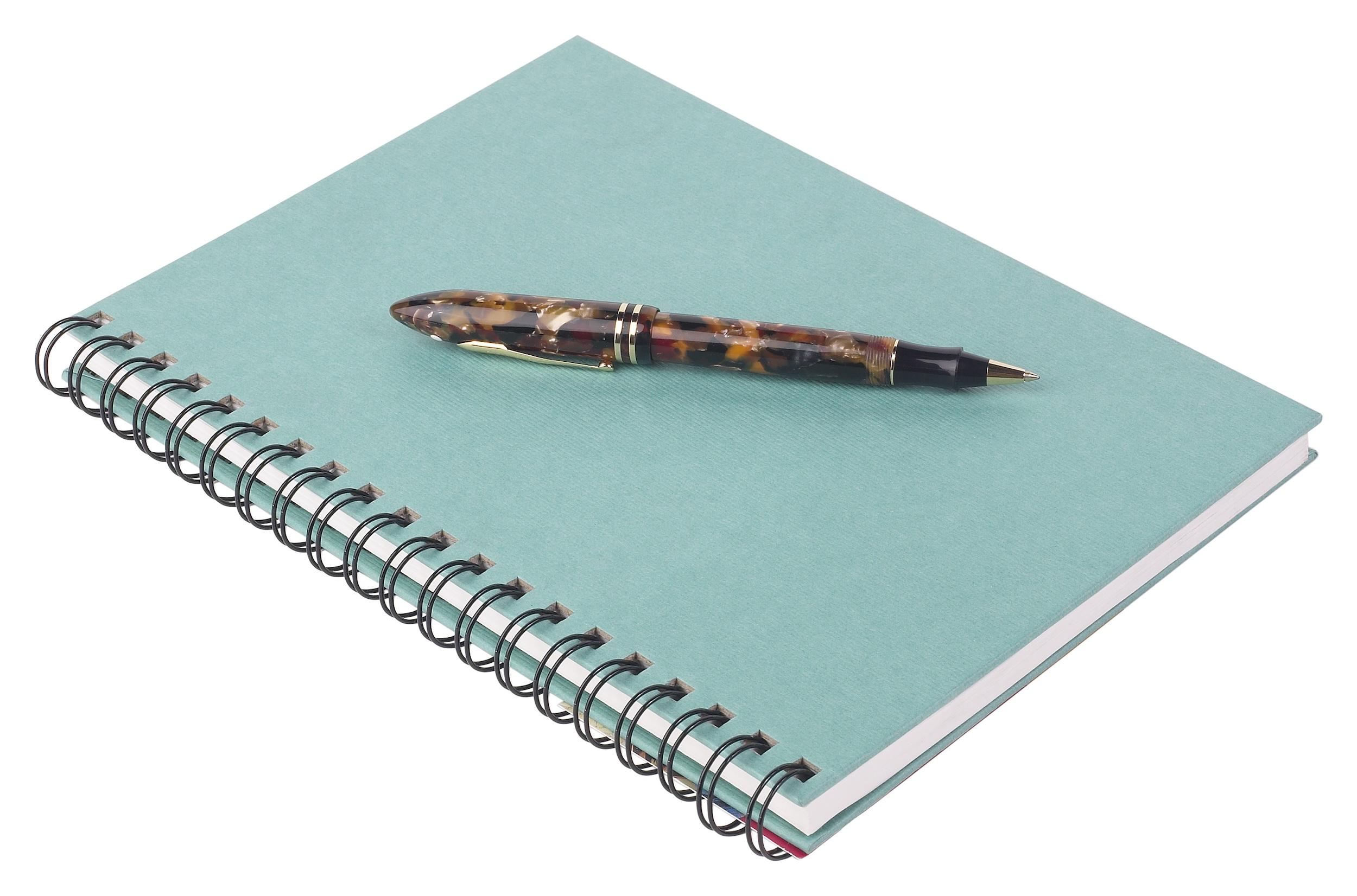 Un quaderno a spirale con copertina rigida in turchese con penna