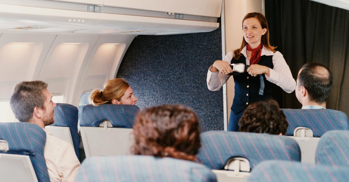 一名女空乘人员向乘客演示安全程序。