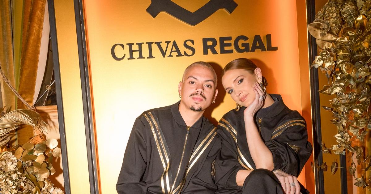 Evan Ross und Ashlee Simpson posieren vor der goldenen Chivas Regal-Kulisse.