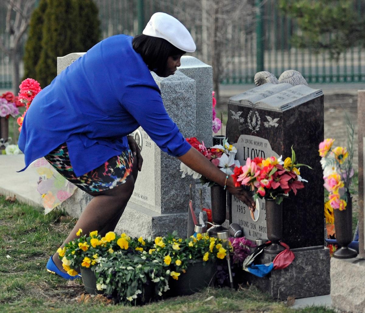 Ursula Ward, mère d'Odin Lloyd, pose sa main sur la tombe de son fils au cimetière d'Oak Lawn à Boston le 15 avril 2015.
