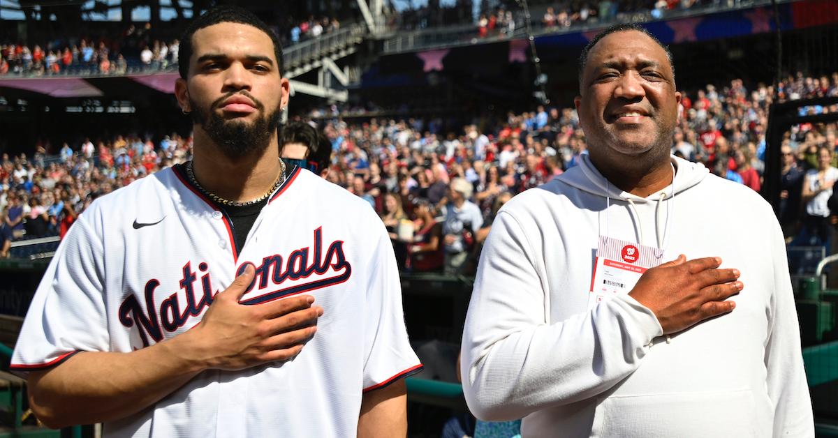 O vencedor do Troféu Heisman, Caleb Williams, à esquerda, representa o hino nacional com seu pai Carl Williams no Nationals Park antes de um jogo com o Detroit Tigers em 20 de maio de 2023 em Washington, DC