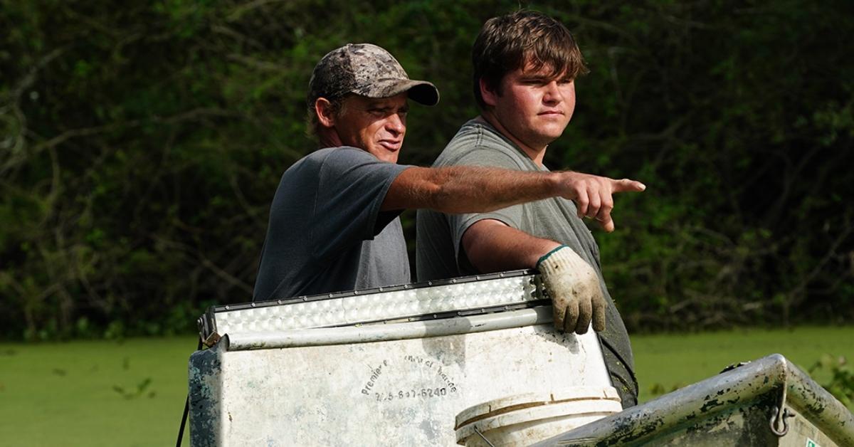 Membros do elenco de 'Swamp People' em um barco à procura de um crocodilo.
