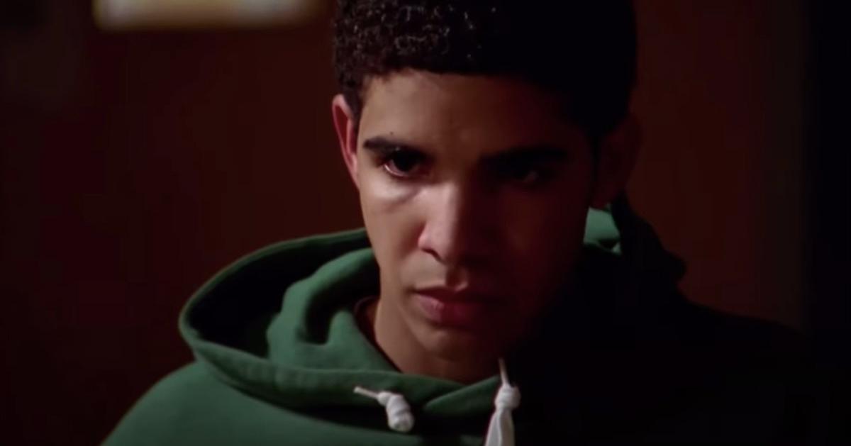 De perto, Drake como Jimmy em 'Degrassi', em que ele usa um moletom verde e parece sério