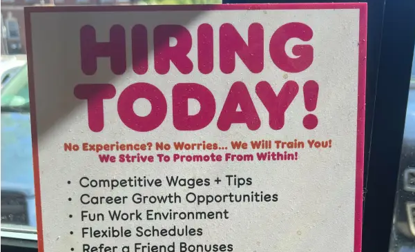 Dunkin' Roasted for Now Hiring-skilt med "Paid Vacation"-job-perk dovent streget over

