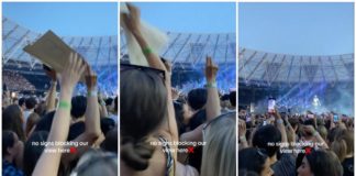視界を台無しにしたとして女性がコンサート来場者の手からポスターを奪う
