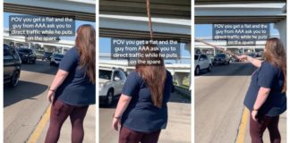 Kvinde dirigerer trafik med en stor pind for at holde AAA-medarbejderen sikker
